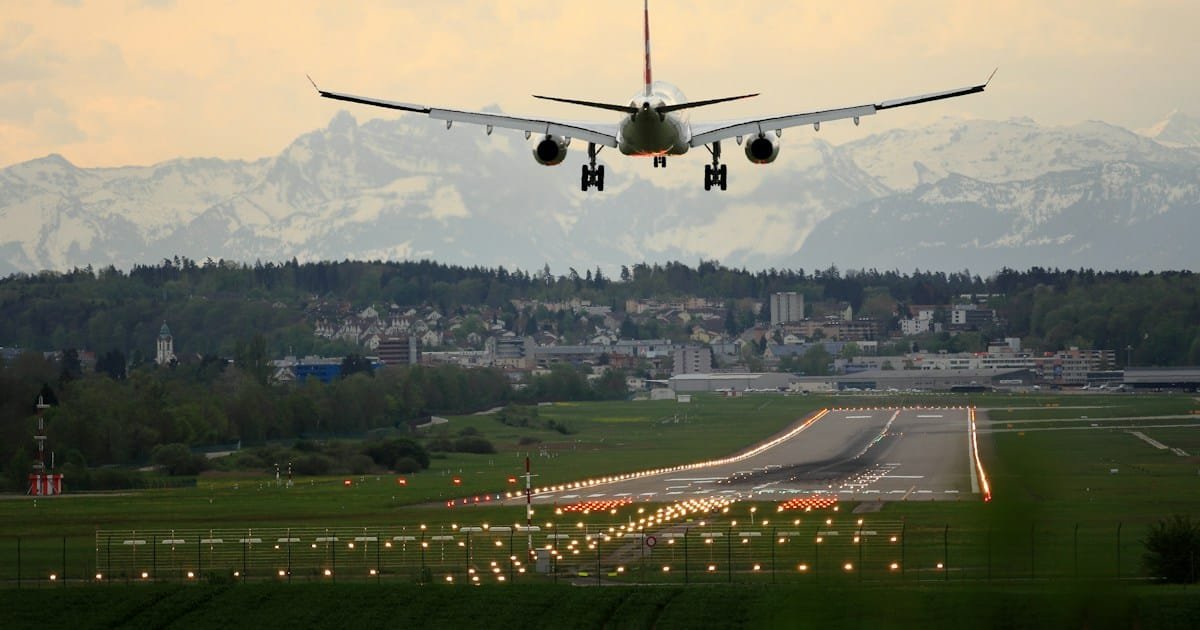 Snowy airport runway with airplane taking off for holiday travel in December